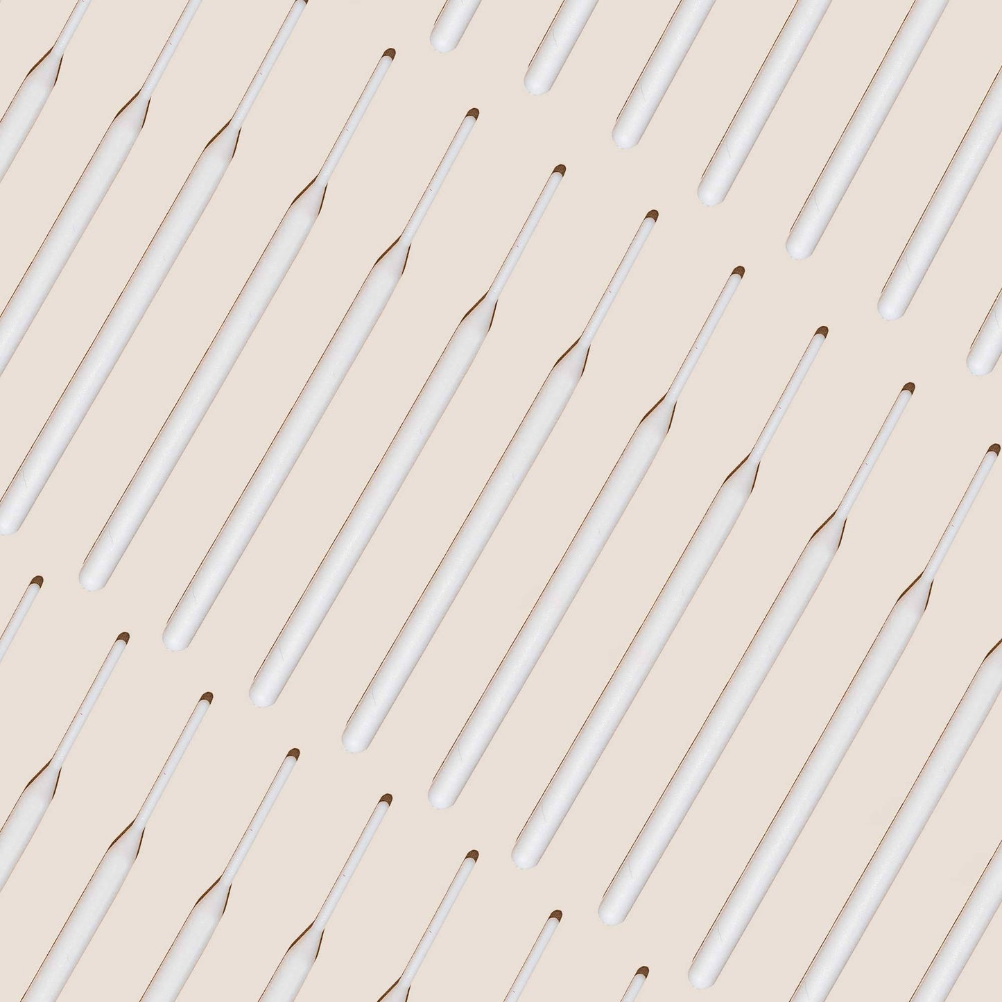 Numerous tinting sticks laid out against an off white background